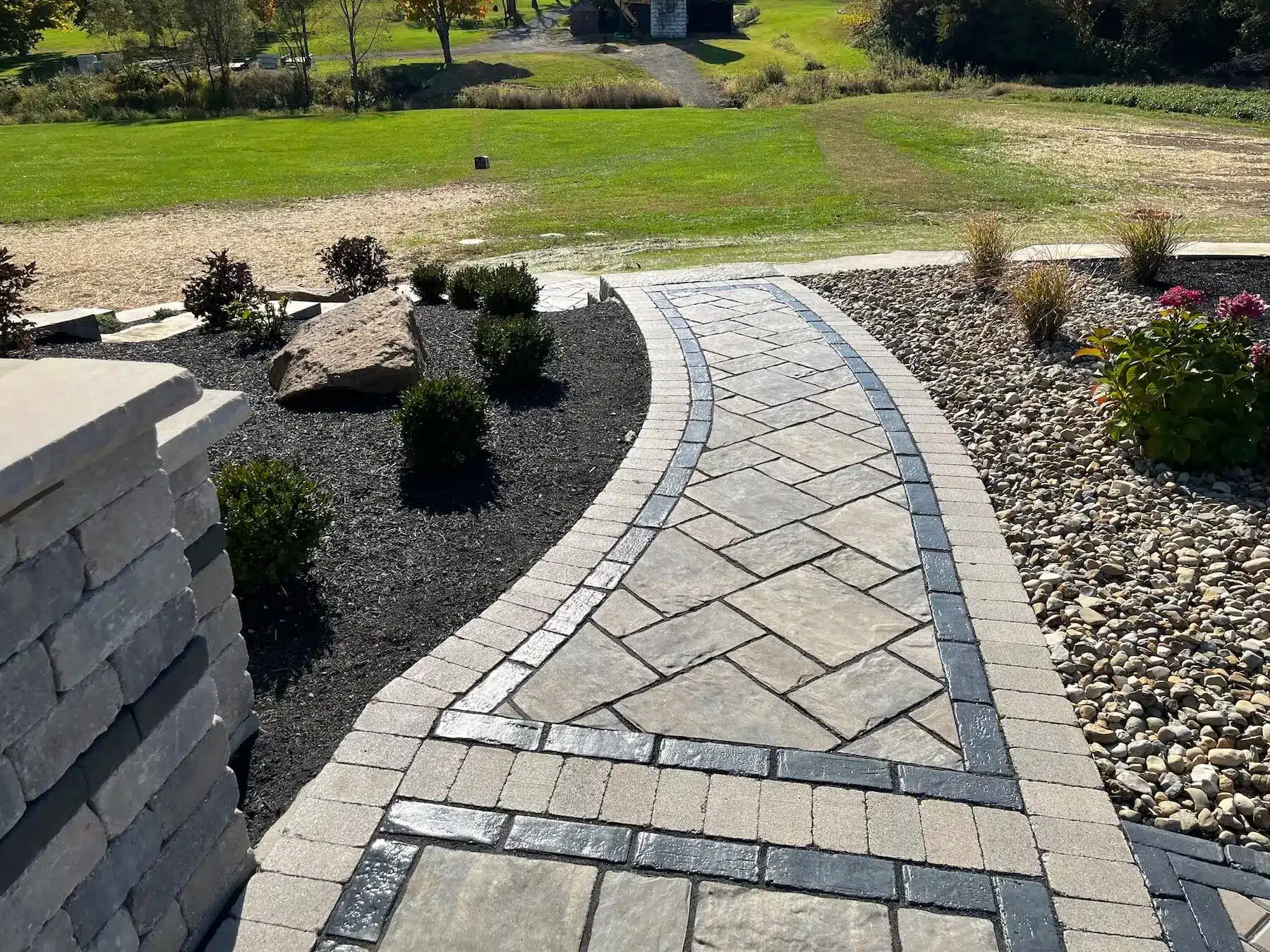 a stone walkway with a lawn and grass